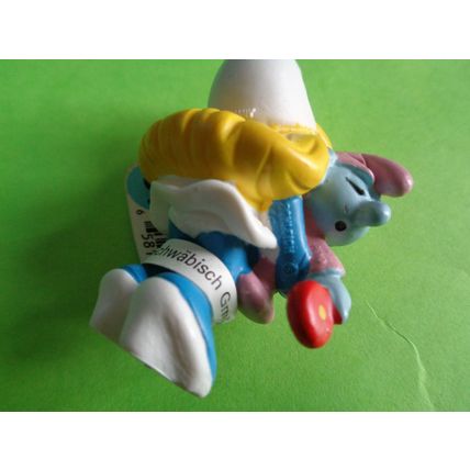 Smurfette smurf holding a pink baby and rattle With a label
