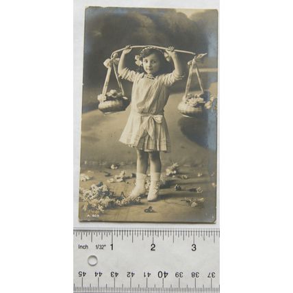 1911 postcard - Girl Holding Up Baskets Of Flowers