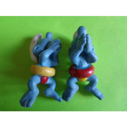 Two swimmers swimming smurfs red and yellow rubber ring