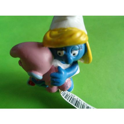 Smurfette smurf holding a pink baby and rattle With a label