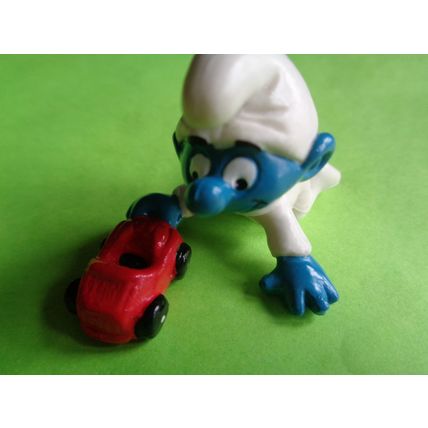 Baby smurf playing with a red toy car