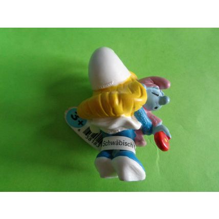 Smurfette smurf holding a pink baby and rattle With a label