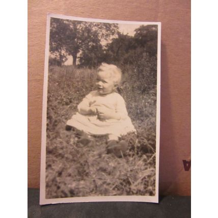 a young girl sat on the grass unused antique postcard real photo (b) =