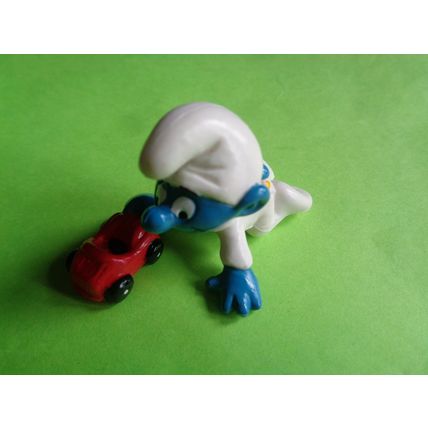 Baby smurf playing with a red toy car