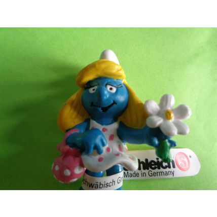 Smurfette smurf holding a flower and bag With a label