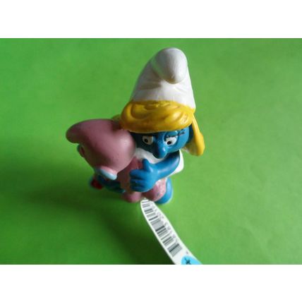 Smurfette smurf holding a pink baby and rattle With a label