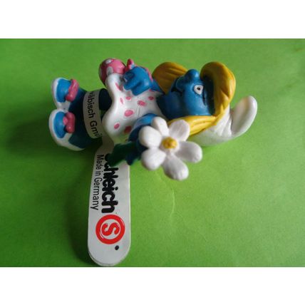 Smurfette smurf holding a flower and bag With a label