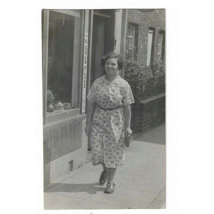 Lady Walking Down Street c1935. RP Postcard.
