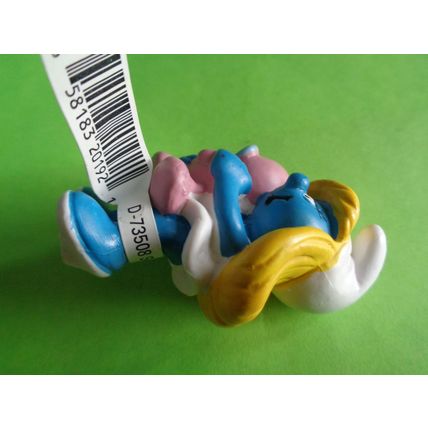 Smurfette smurf holding a pink baby and rattle With a label