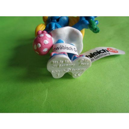 Smurfette smurf holding a flower and bag With a label