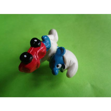 Baby smurf playing with a red toy car