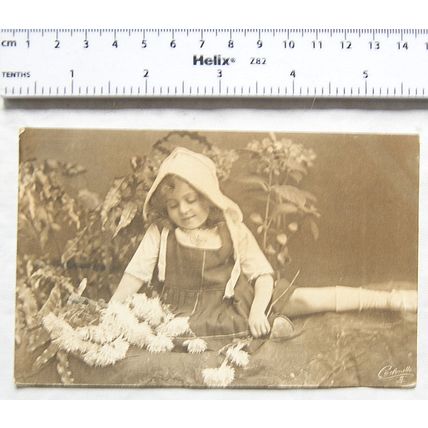 1921 postcard - Girl among the flowers