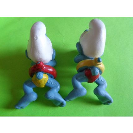 Two swimmers swimming smurfs red and yellow rubber ring