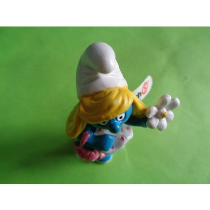 Smurfette smurf holding a flower and bag With a label