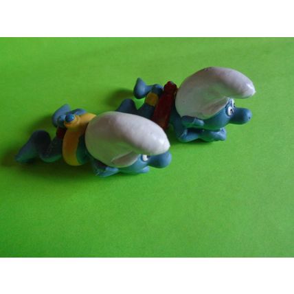 Two swimmers swimming smurfs red and yellow rubber ring