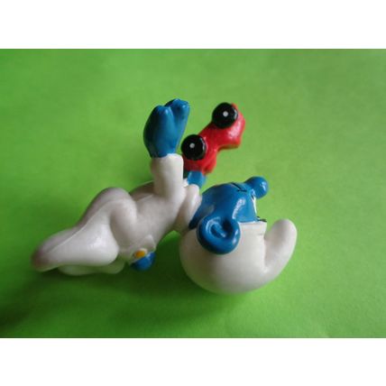 Baby smurf playing with a red toy car