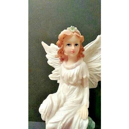 PRETTY WHITE SPARKLING FAIRY SITTING ON A CLEAR STRUCTURE.