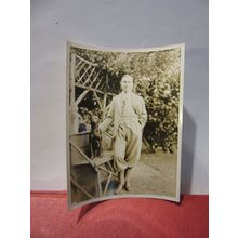 A MAN AND HIS DOG ON A GARDEN SEAT, 1930s? photograph =