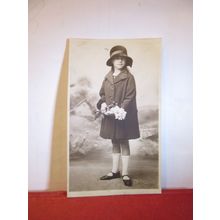 A PRETTY YOUNG GIRL WITH DAFFODILS . photograph postcard blank back =