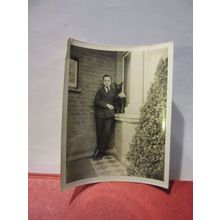 A MAN AND HIS DOG ON A WINDOW SILL, 1930s? photograph =