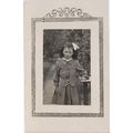 Vintage postcard young girl in a garden. Button...