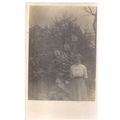 LADY IN FRONT OF GIANT HOLLYHOCK FLOWERS .unuse...
