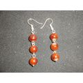 Six plain polished tawny brown beads dangle swi...